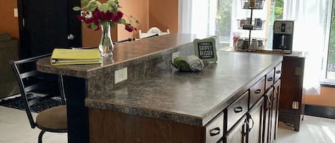 Kitchen island with prep space and raised top for four bar stools