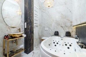 Modern bathroom with a hot tub, sink with mirror and toilet decorated in a unique style with gold accessories.
