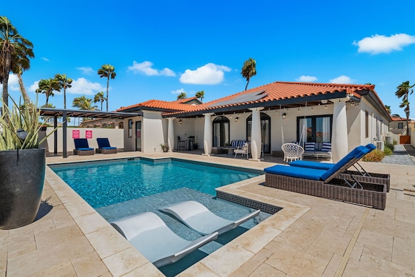 Luxury pool area of the Villa in Noord Aruba - Lush and refreshing environment - Cozy beach chairs available - Beautifully sunbathed space makes the soul peaceful - Experience the comfort at the best