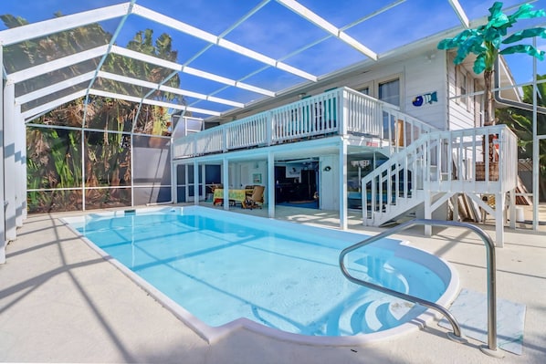 The fully screened lanai creates an enjoyable outdoor living space, with deck, heated pool, kitchen and dining.