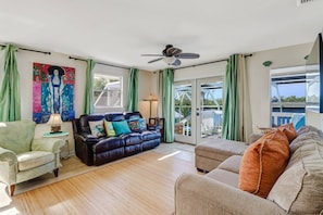 The main living space, flooded with sunlight, includes a leather reclining sofa and sectional with chaise.