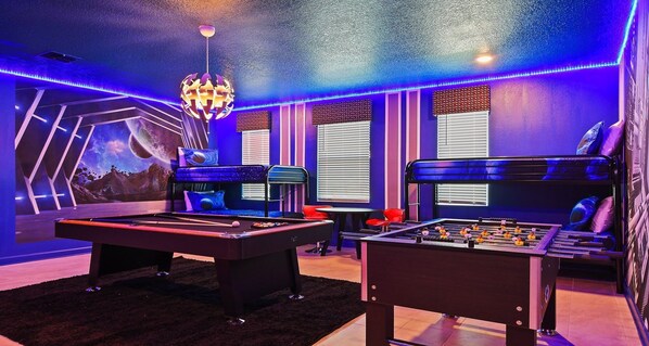 The game room bedroom is impeccably furnished with a Star Wars theme, enhanced by cool lights, creating a unique and captivating ambiance.