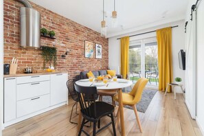 Living room with double sofa bed, TV, access to the balcony and dining area.