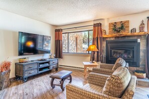 Living area featuring a gas fire place, private balcony access, and cozy furniture.