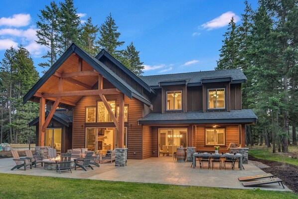 Timber-Framed Luxury Home With Dramatic Rooflines And Glowing Entry Lighting