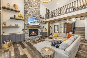 Living Room With Vaulted Ceilings, Floor-To-Ceiling Gas Fireplace + Plush Sofa