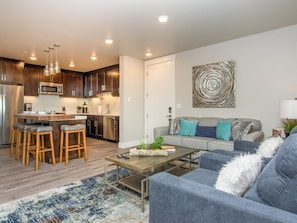 Family room open to kitchen area with sofa and 2 chairs