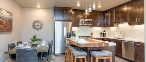 Designer open concept kitchen with bar seating and dining table