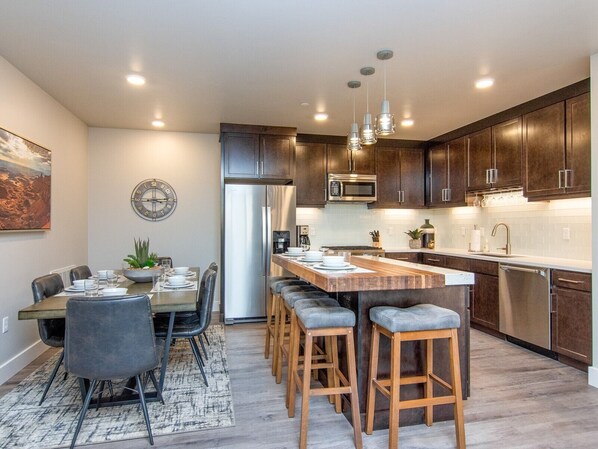 Designer open concept kitchen with bar seating and dining table