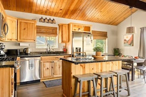 Fully stocked kitchen has everything you need for a memorable meal. Seating for three at the spacious kitchen island.