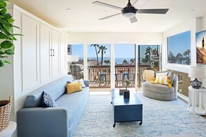The living room includes a king-sized sofa Murphy Bed that converts to a "real bed" in less than one minute! The bed is made up with bedding ready for sleep and the pillows are stored in this blue storage ottoman.
