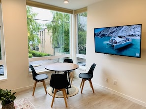 Dining table and chairs that fit 4 people with a 55'' TV in the living room.