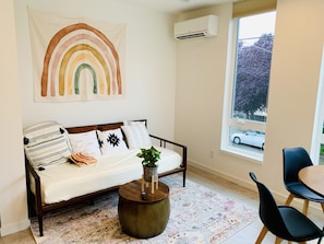Living room with cozy safe bed and rainbow wall decor!