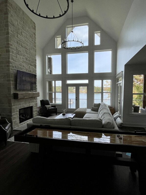 Large 2 story family room overlooking the lake with shuffleboard table. 