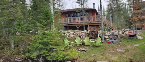 View of cabin and guest firepit from dock / lake