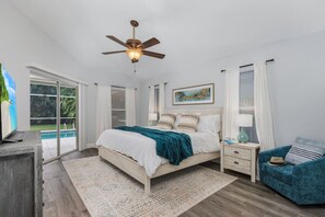 Primary bedroom with pool access, king size bed, smart TV, walk-in closet and private bathroom