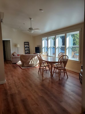 Dining table and living room with TV and two couches.