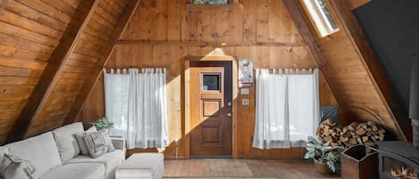 Classic a-frame style with wood burning stove in the primary living room.