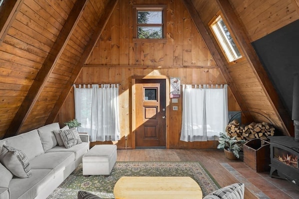 Classic a-frame style with wood burning stove in the primary living room.