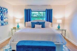 Sophisticated primary bedroom with palm tree view and lanai access.