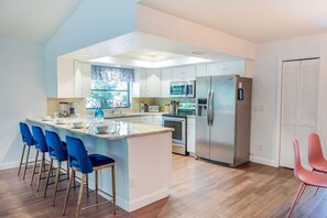 Large renovated kitchen has adjacent 6-top dining area and bar seating for 4.