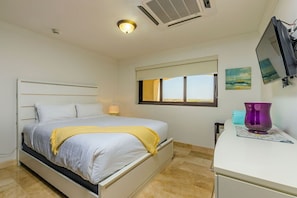 Large bedroom with one queen bed, television, view, and other amenities.