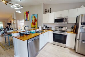 Fully Equipped Modern Kitchen with All Stainless Appliances, Unique Wood Surfaces, and Extra Small Appliances