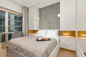 Stylish and modern bedroom with a double bed, desk with chair and mirror.