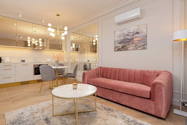 Elegant and modern living room with a comfortable sofa bed, Smart TV and kitchenette with dining area.