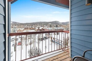 Private outdoor balcony with stunning river, forest, and mountain views as seen in winter.