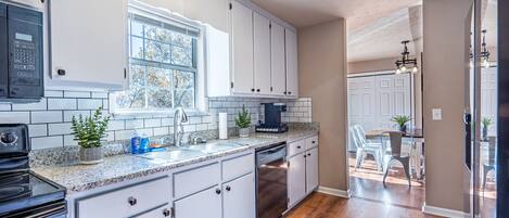 The kitchen has easy access to the dining table.