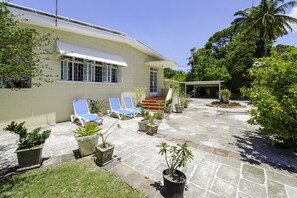 Front yard with covered parking on the left of the photo.