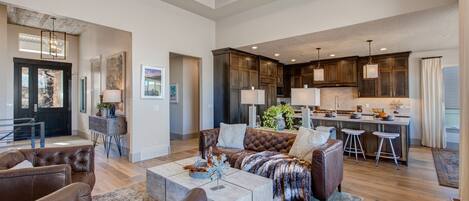 Upper level living room with leather furnishings, smart TV, gas fireplace, and reading bench