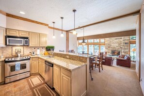 The updated kitchen is fully stocked and has granite counter tops, full size stainless steel appliances, and breakfast bar top seating for three.