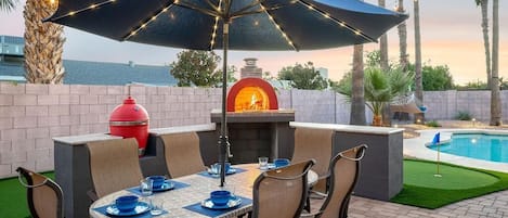 Private backyard with pool, putting green, corn hole, pizza oven, gas grill, outdoor dining, a hammock and more! 