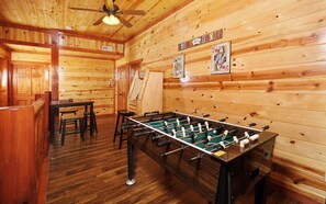 Game room with foosball table, arcade cabinet, and seating area.