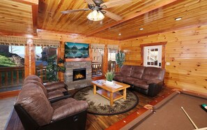 Cozy living room with fireplace, big screen TV, and mountain views.