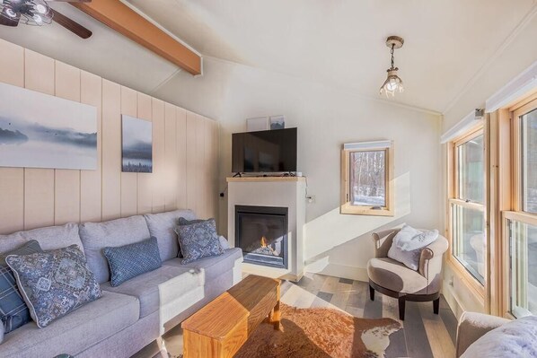 Relax in this cozy well decorated living room with a 50" smart tv, fireplace, couch with sleeper sofa.