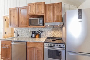 The small kitchen is well equipped with pots/pans and all items a typical kitchen has.