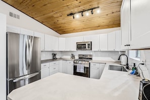 Renovated kitchen with tongue and groove ceiling, brand new countertops, and all the amenities to enjoy a home cooked meal