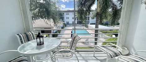 Screened balcony overlooking the pool has dining table and chairs for relaxing. 