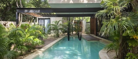 Impressive pool located in the courtyard with hanging hammocks over it.