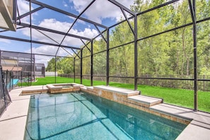 Screened backyard with heated pool and spa