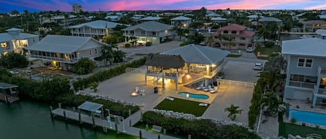 Aerial twilight views of the home, dockage, private pool, large fenced in yard