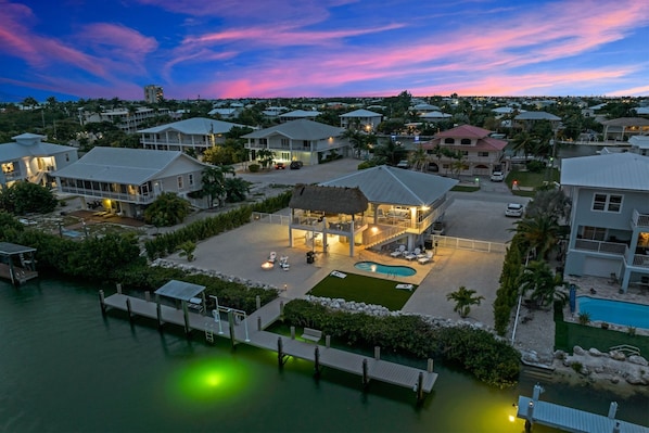 Aerial twilight views of the home, dockage, private pool, large fenced in yard