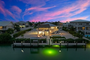 Aerial twilight views of the home, dockage, private pool, large fenced in yard