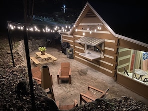 The outdoor space is perfect for entertaining, featuring Adirondack chairs and a cozy fireplace for evening gatherings.