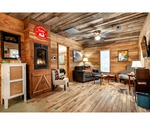 Relax by the fireplace in this inviting cabin living room. Thoughtful touches make this space feel like home.