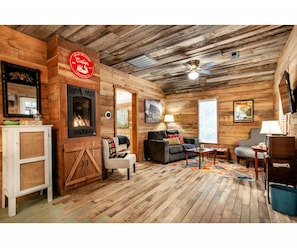 Relax by the fireplace in this inviting cabin living room. Thoughtful touches make this space feel like home.