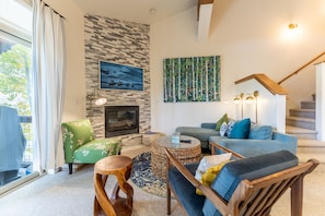 Living area featuring cozy furnishings, a gas fireplace and mounted TV.